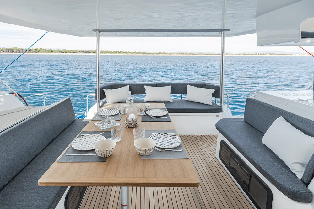 Salon extérieur aménagé sur le pont arrière du catamaran Aventura 37 à l'Estartit.